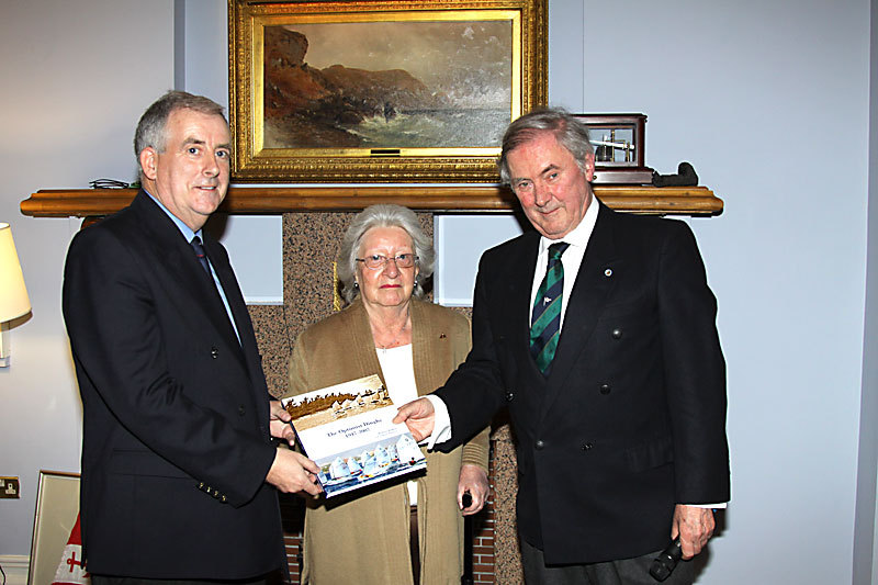 The Commodore is presented with 'The Optimist Dinghy' by Helen Mary and author Robert Wilkes