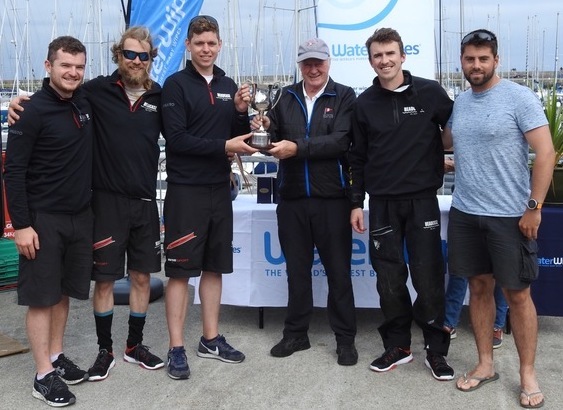 Commodore Paddy Judge presents the overall trophy to Cillian Dickson and the team from 'Headcase'